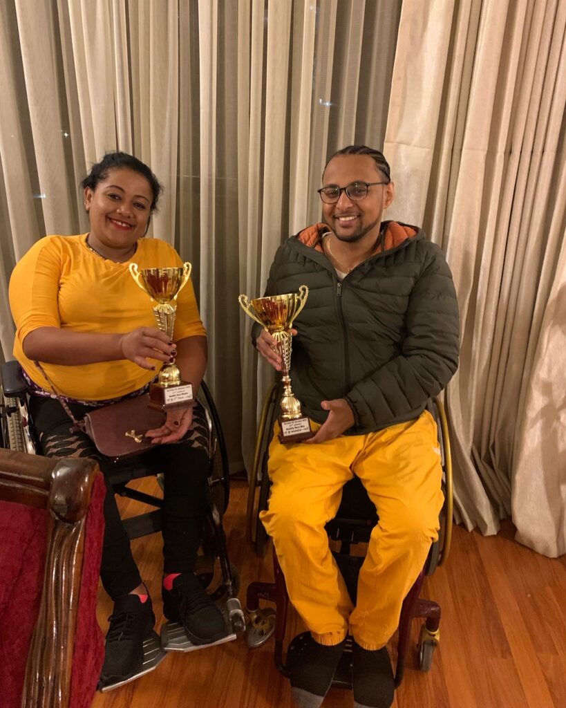 Addis Gonte photographed with another wheelchair race competitor with trophies