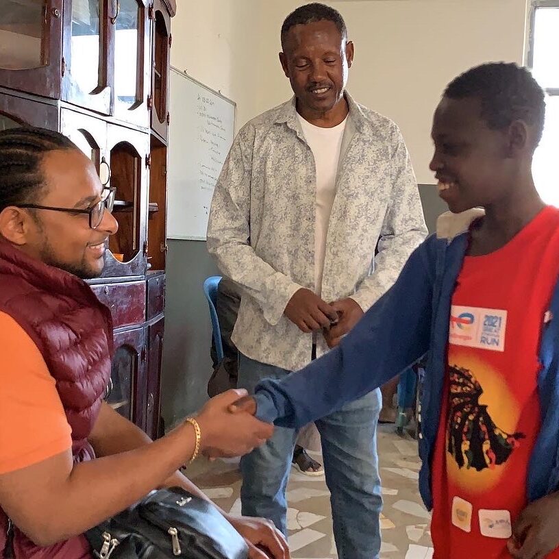Addis of Able Mindset shaking hands with a young man.